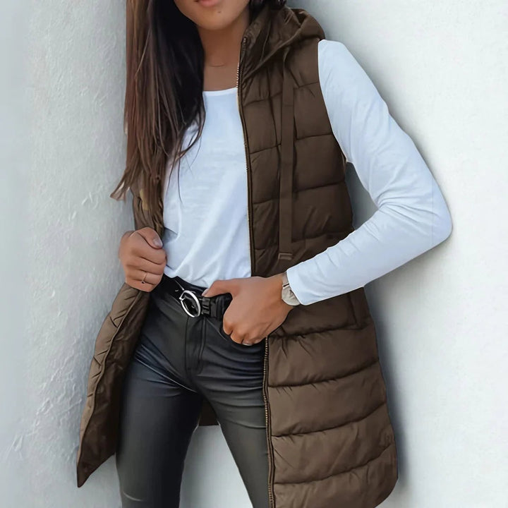 Primer plano de tejido acolchado en chaleco largo con capucha. Calidad y abrigo para mujer en invierno.