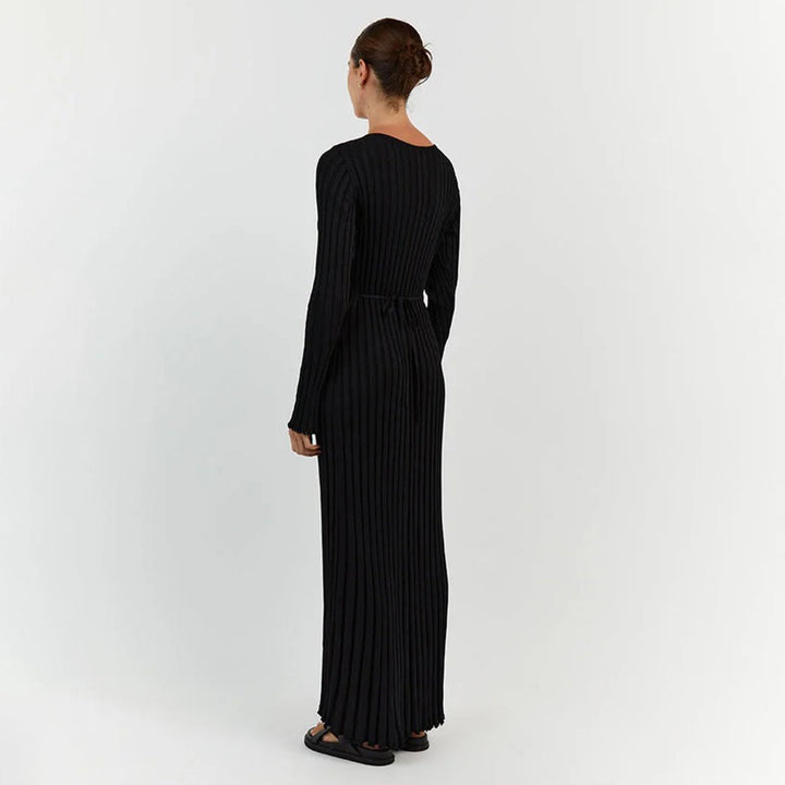 Mujer posando con vestido maxi de punto, destacando su adaptabilidad y confort en un estilo femenino.