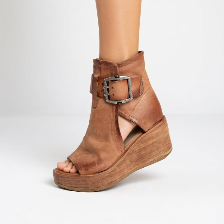 Calzado femenino elegante: sandalias de cuña con distintiva hebilla metálica, para un look sofisticado.
