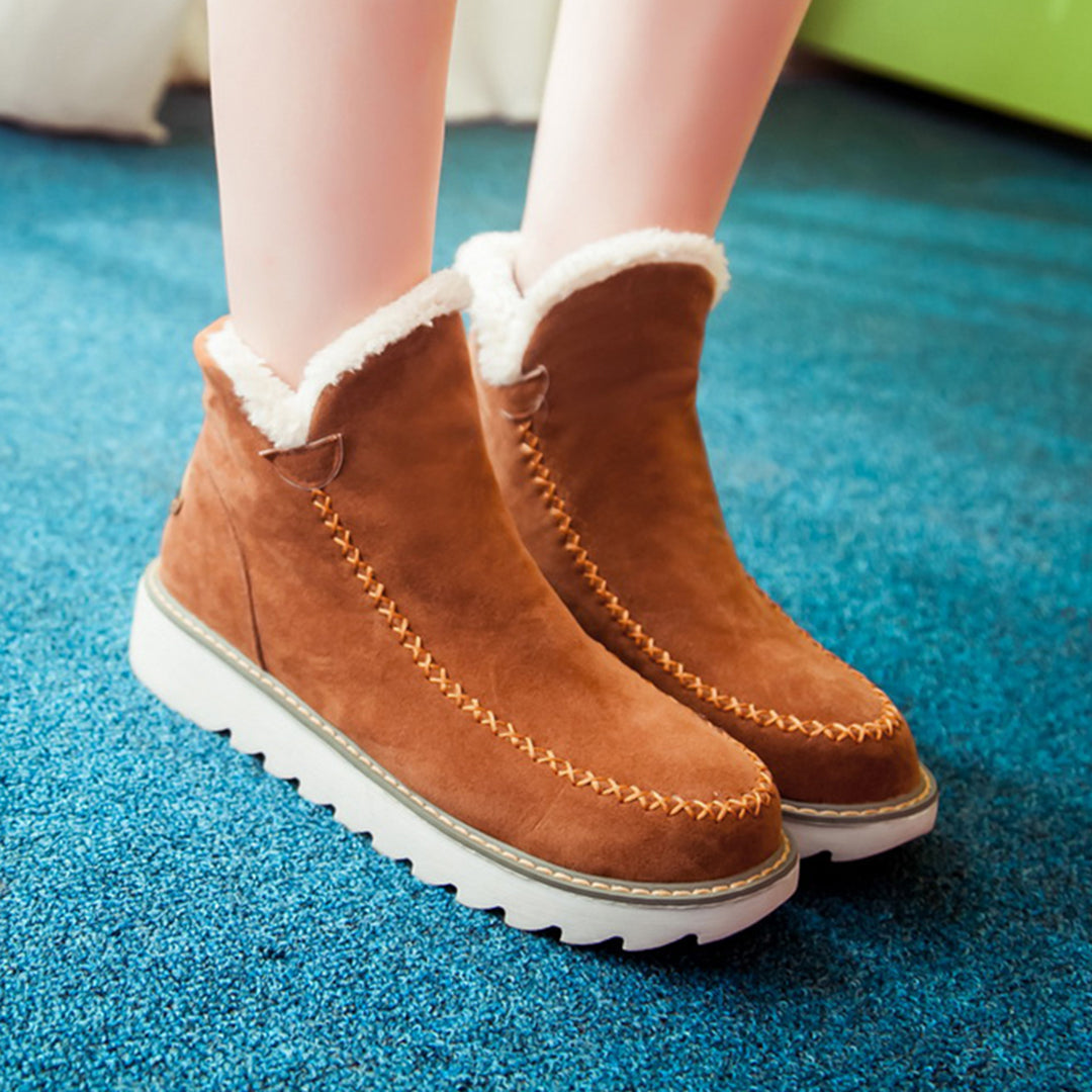 Interior forrado con borreguillo de botas de invierno de mujer, brindando máxima calidez y comodidad contra el frío.