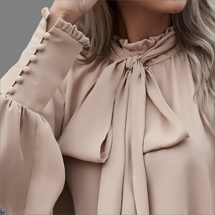 Blusa sofisticada de mujer con lazo decorativo y mangas largas. Perfecta para moda casual o formal.