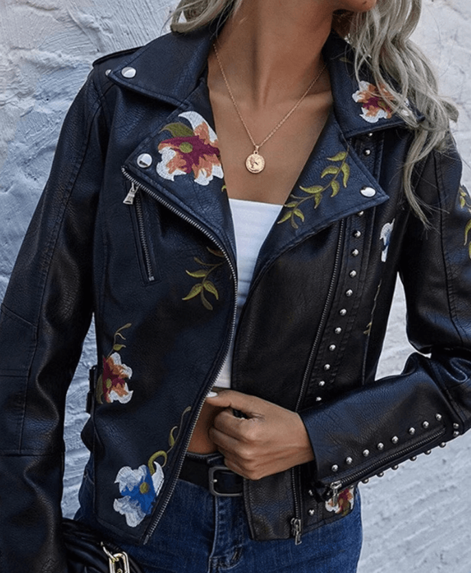 Chaqueta biker negra de cuero sintético para mujer con flores bordadas y tachuelas. Elegancia audaz.