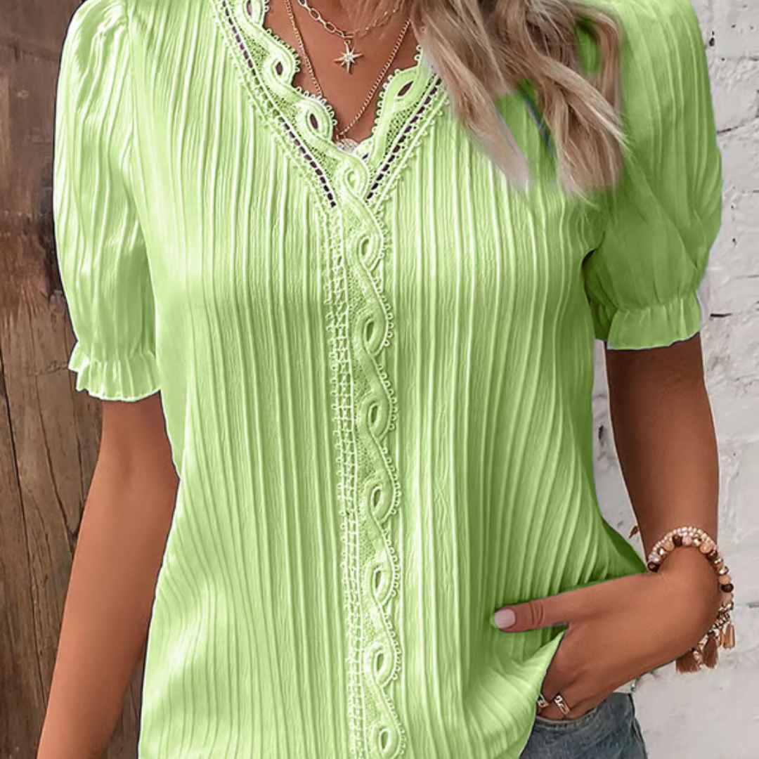 Primer plano del escote en V de la blusa de encaje. Ideal para tops elegantes y celebraciones.