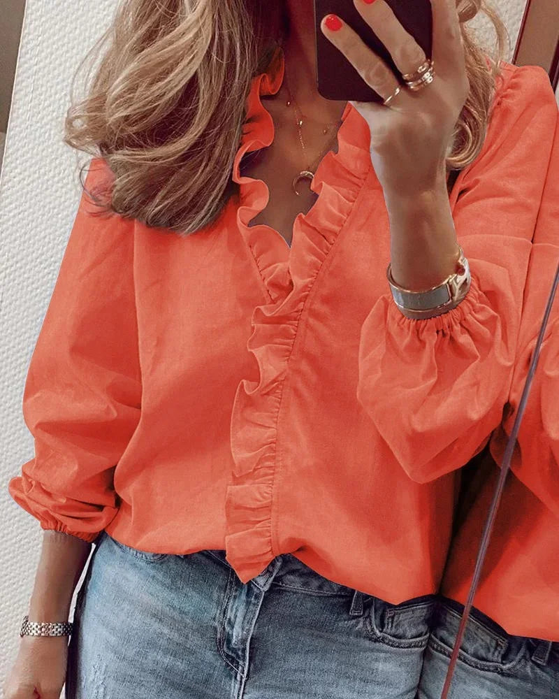 Blusa holgada de mujer con volantes y cuello V. Manga larga, perfecta para un look casual y cómodo.