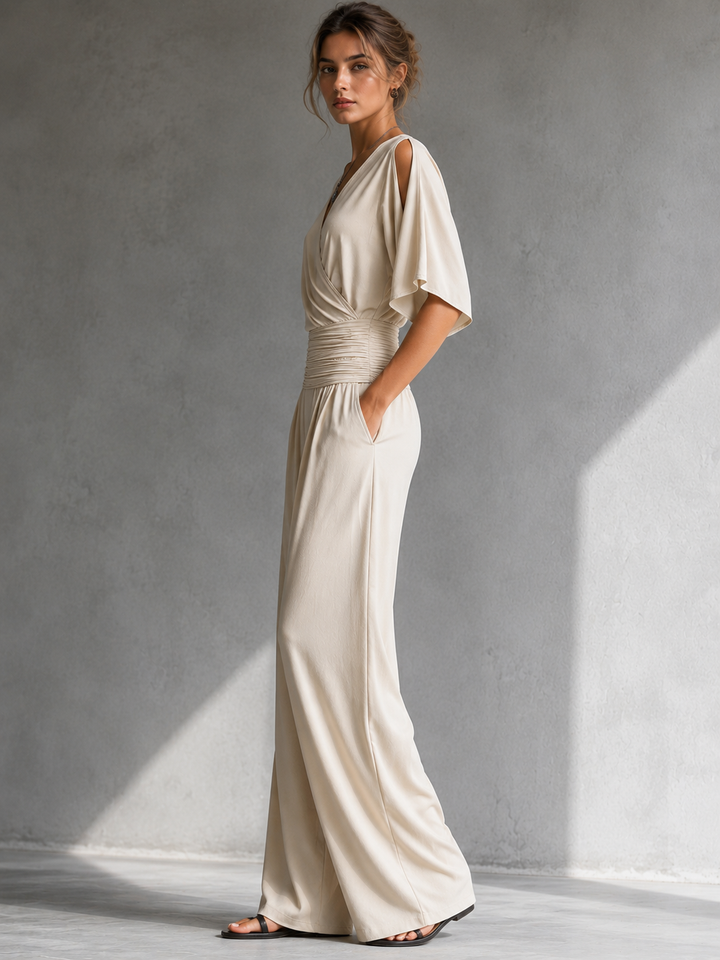 Mono elegante femenino con escote cruzado, cintura fruncida y pierna ancha. Ideal para eventos.