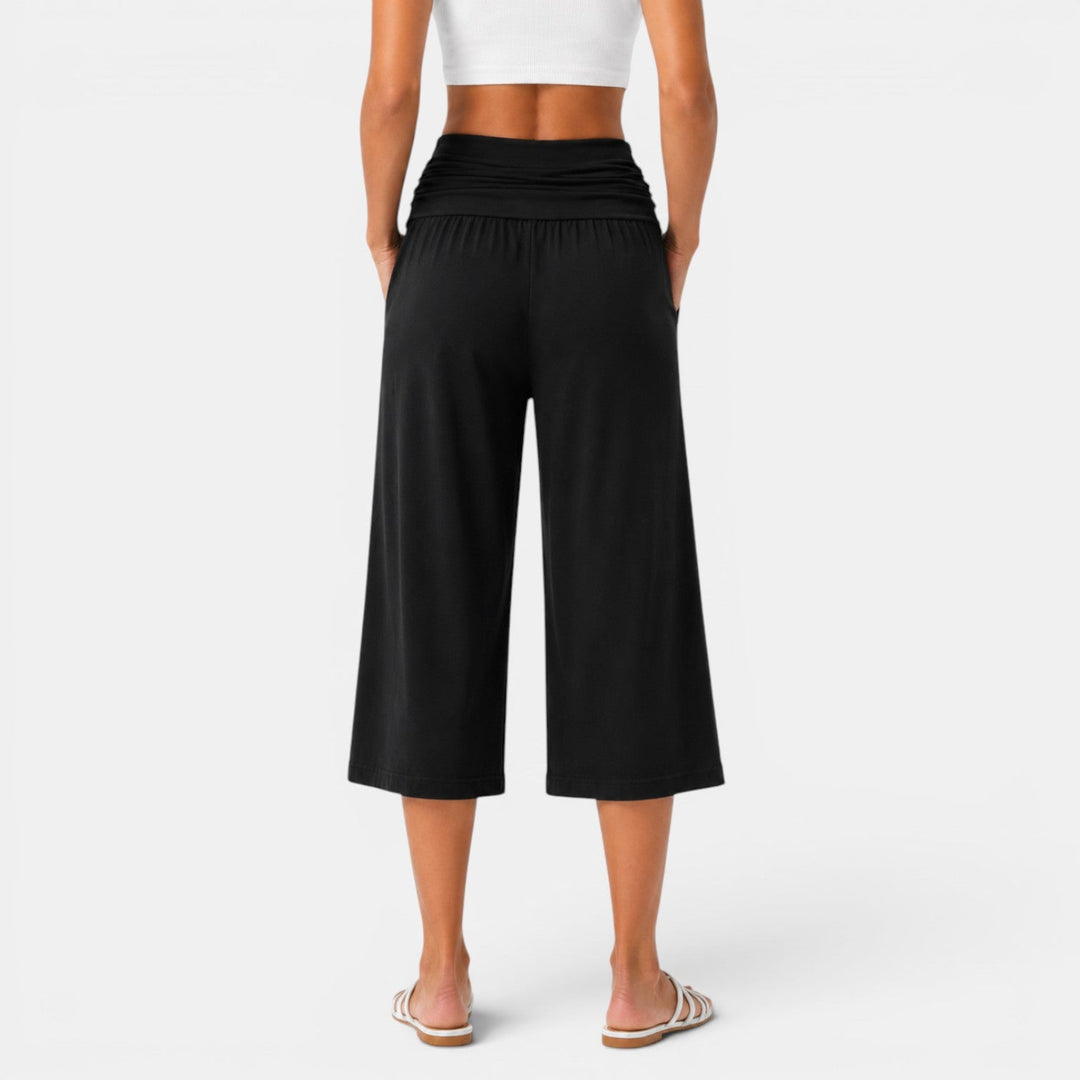 Pantalón capri de yoga elástico. Mujer en pose de yoga, transpirable, cómodo para fitness y deporte.
