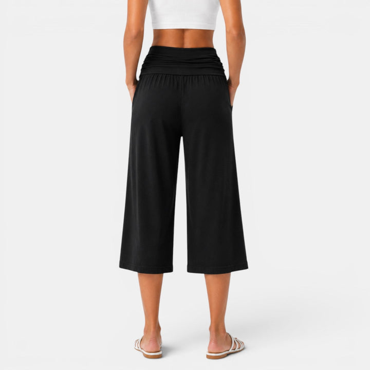 Pantalón capri de yoga elástico. Mujer en pose de yoga, transpirable, cómodo para fitness y deporte.