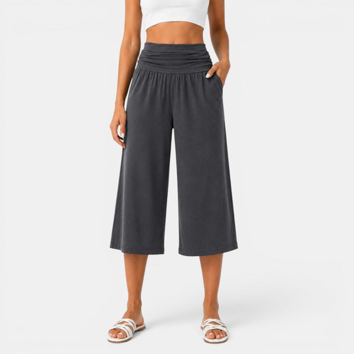 Mujer luciendo pantalón capri de yoga, elástico y transpirable. Ideal para fitness, deporte y comodidad activa.