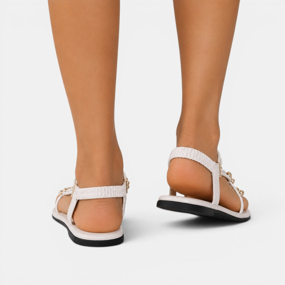 Par de sandalias planas para mujer con pedrería, diseño moderno y cómodo para disfrutar del verano.