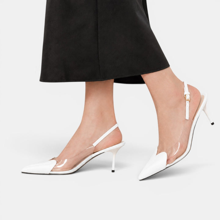 Primer plano de tacones transparentes con detalle de corazón, mostrando diseño único y moda femenina.