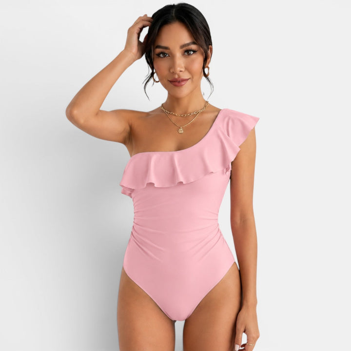 Bañador de mujer con volante asimétrico, ideal para disfrutar del sol en la playa. Traje de baño.