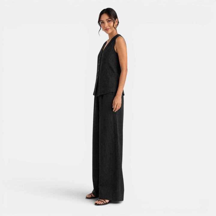 Mujer luciendo conjunto de lino azul marino: chaleco y pantalón pierna ancha. Moda de verano versátil.