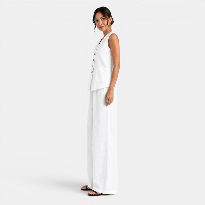 Mujer con conjunto de lino blanco, chaleco y pantalón ancho. Ideal para oficina o un look casual chic.