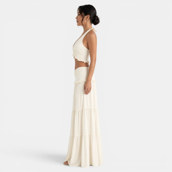 Elegante conjunto de dos piezas con top halter y falda larga fluida de volantes para mujer.
