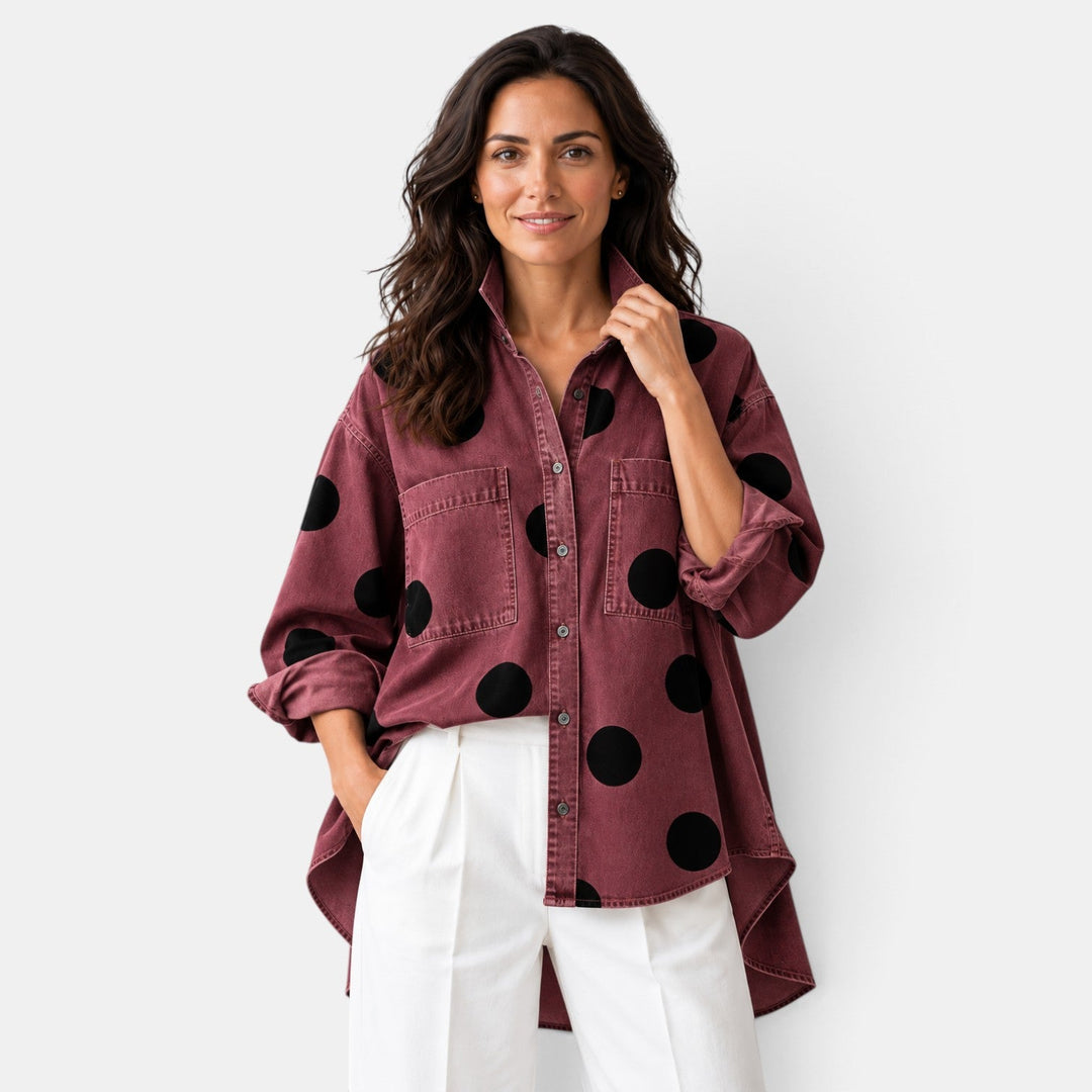 Camisa de mujer elegante de lunares en percha. Blusa con botones y manga larga, estilo versátil para ropa femenina.