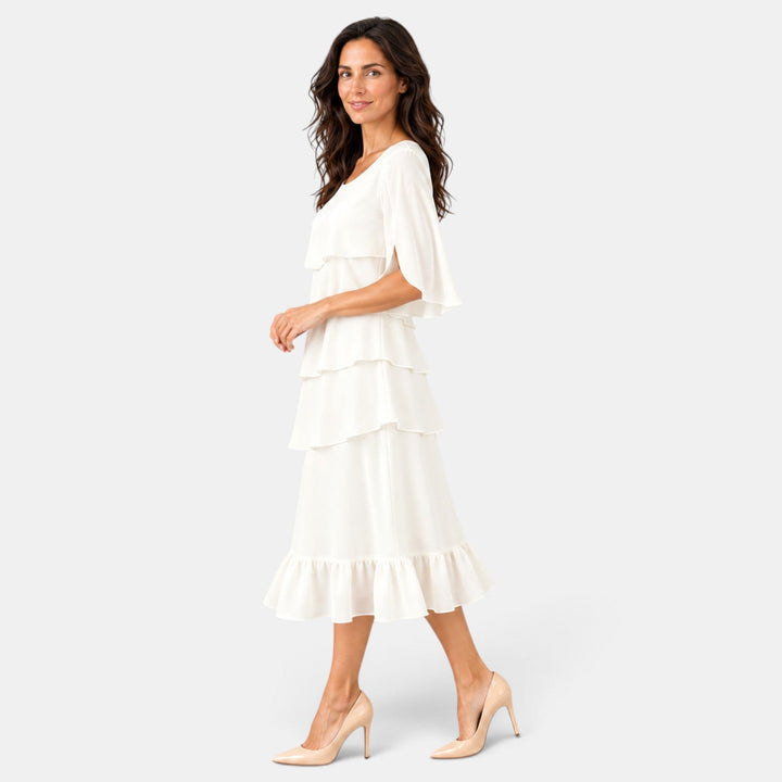 Vestido midi de corte elegante para invitada de boda, con volantes decorativos y mangas abiertas que añaden estilo.