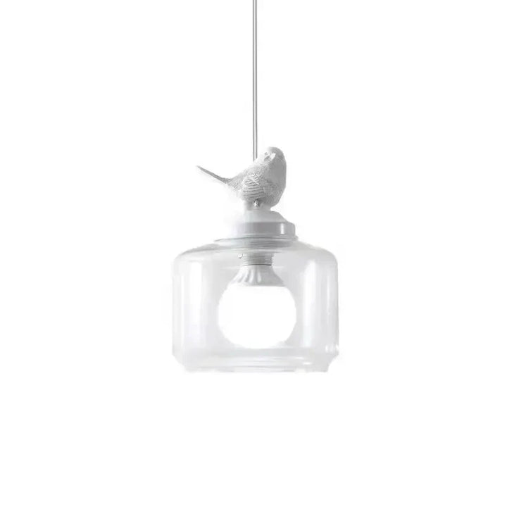 Lámpara colgante con pájaro de diseño. Cilindro de vidrio transparente, crea ambiente acogedor.
