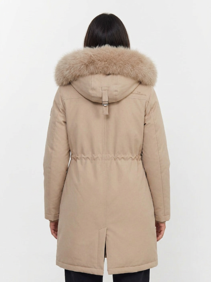 Detalle de la capucha con pelo sintético en la parka de invierno para mujer, ajustable y cómoda.