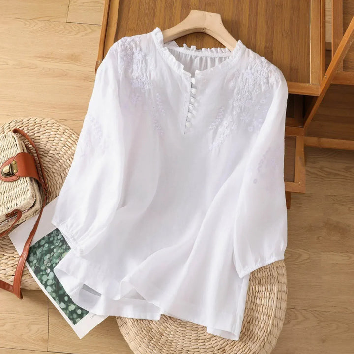 Blusa blanca bordada de mujer con manga larga y cuello volante. Estilo romántico, perfecta para primavera-verano.