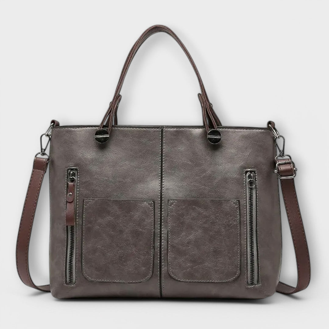 Bolso tote negro con cremallera y bolsillos internos, accesorio de moda elegante para mujer.