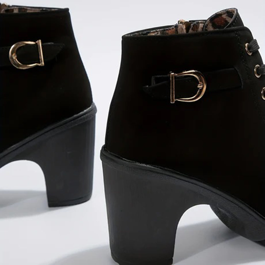 Detalle de tacón cómodo en botines elegantes de cuero sintético para mujer, estilo y confort.