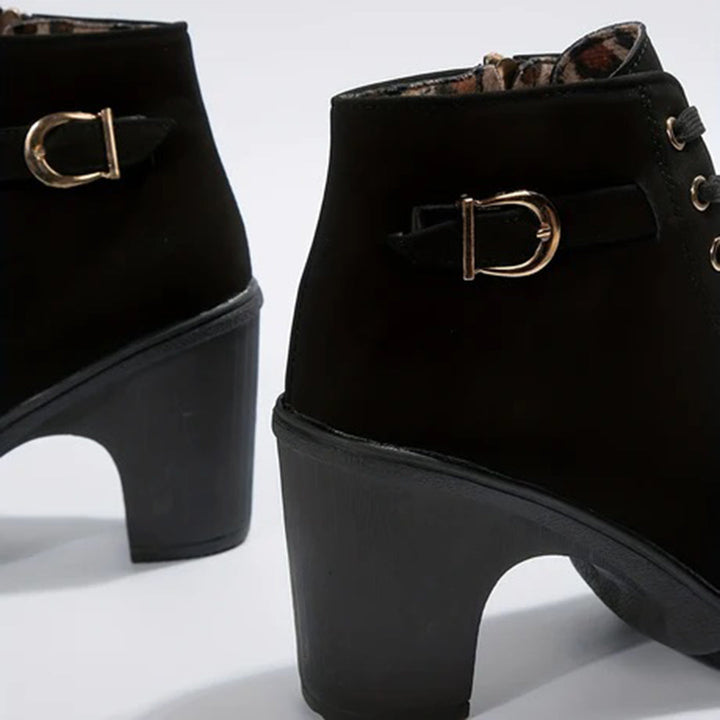 Detalle de tacón cómodo en botines elegantes de cuero sintético para mujer, estilo y confort.
