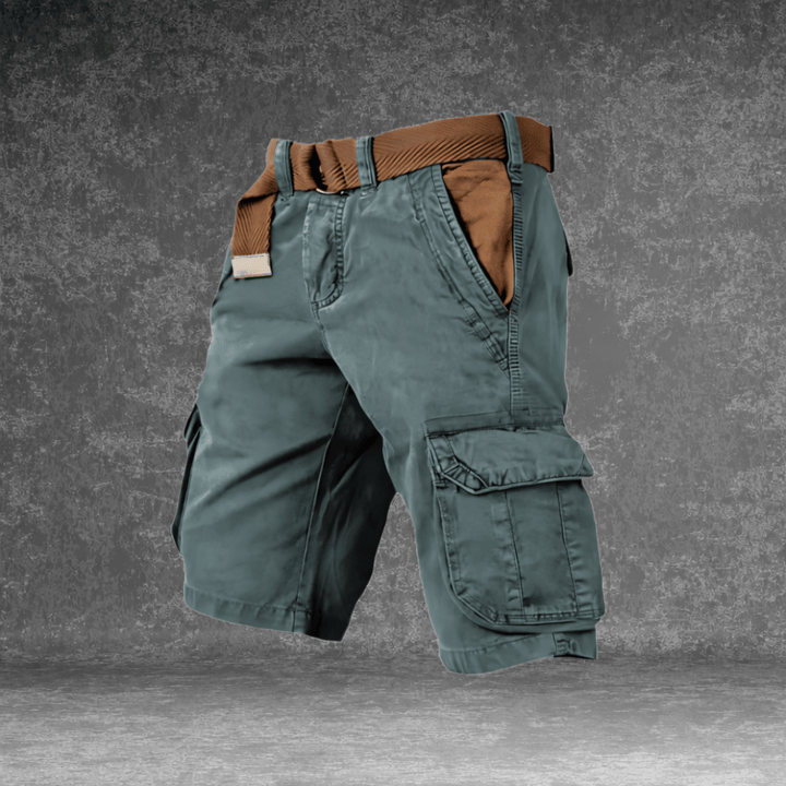 Hombre de pie con pantalón corto cargo MAVERICK, mostrando ajuste y estilo casual para verano y viaje.