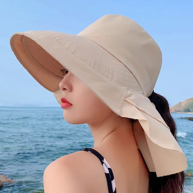 Sombrero de sol de mujer con ala ancha y protección UV para verano en la playa.