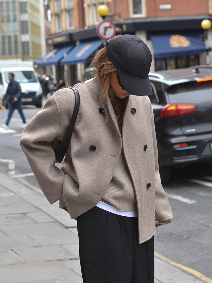 Chaqueta corta de mujer gris, diseño doble botonadura, ideal para moda femenina de entretiempo.