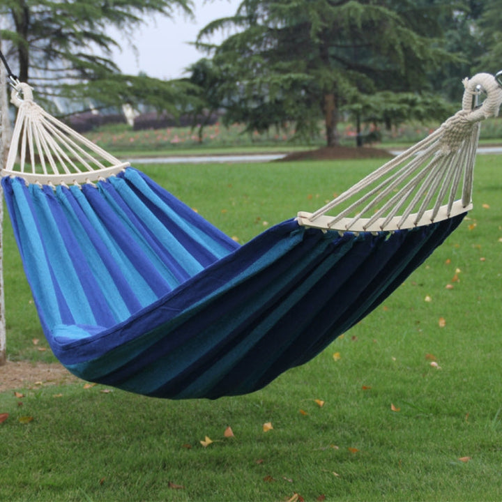 Hamaca de lona azul para exterior e interior con barra curvada removible, ideal para jardín y relax.