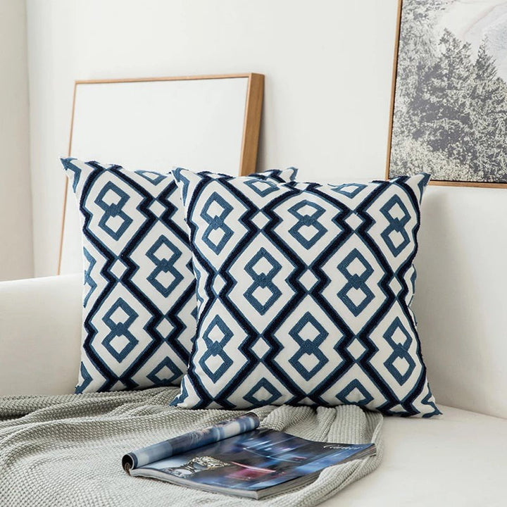 Textil de hogar: cojín decorativo azul bordado geométrico. Acento moderno y elegante para tu sofá.