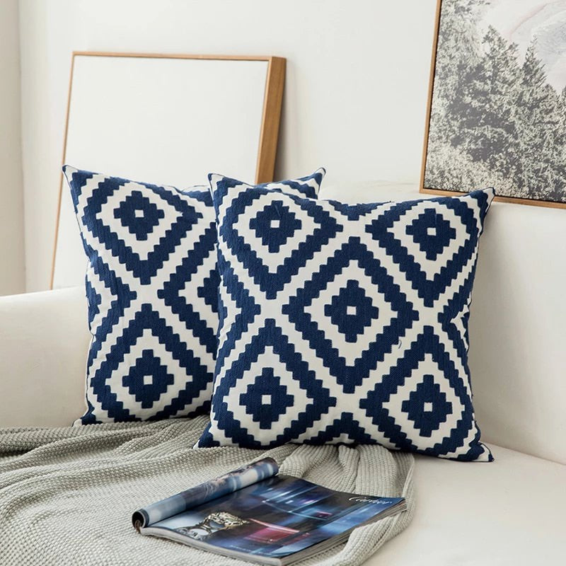 Cojín decorativo bordado azul, diseño geométrico contemporáneo. Perfecto para sofá, aporta un toque moderno.