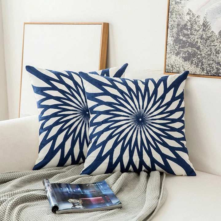 Cojín decorativo azul bordado con patrón geométrico moderno para sofá, ideal para salón y hogar.