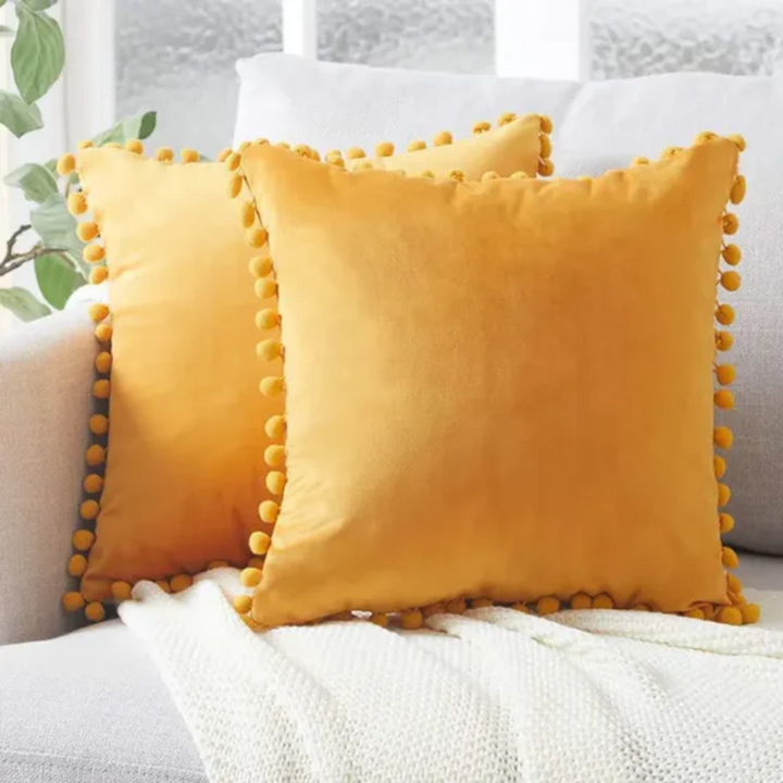 Cojín bohemio con flecos y pompones, un toque decorativo único. Realza tu dormitorio o sala con su textura suave.