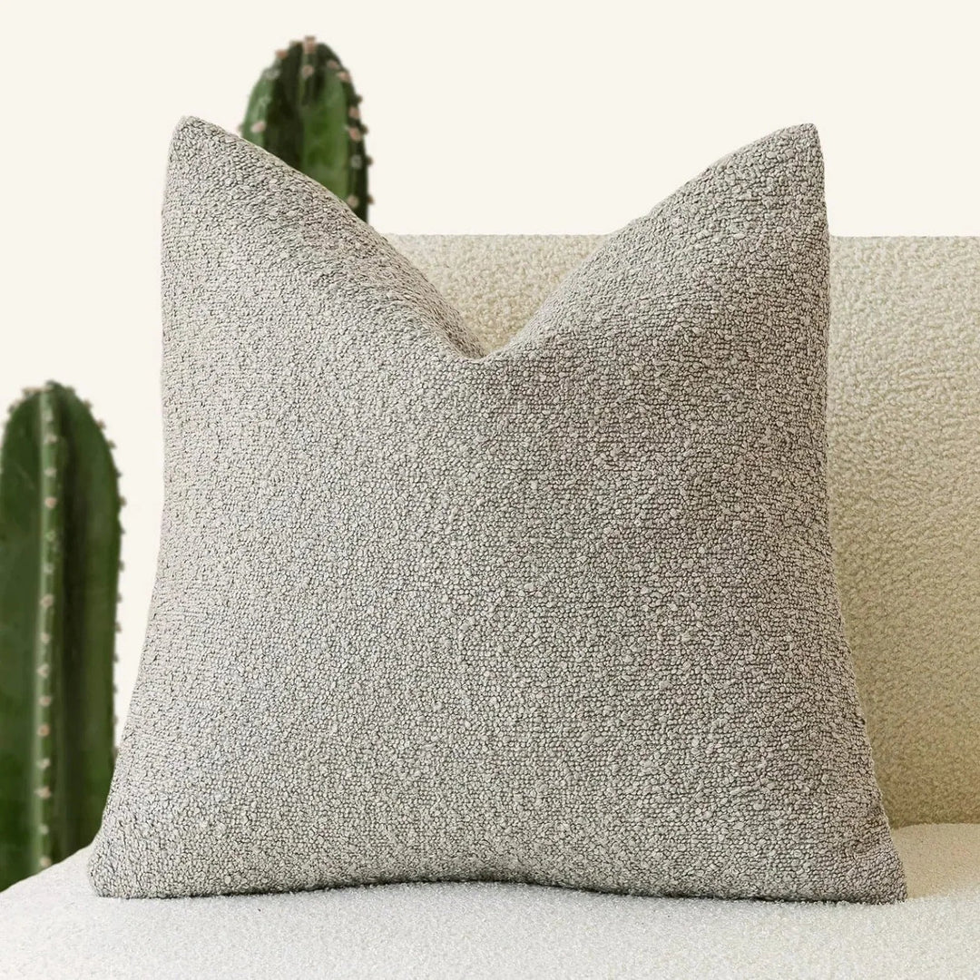 Funda cojín boucle 45x45cm, accesorio decorativo para sala. Aporta calidez y estilo minimalista.