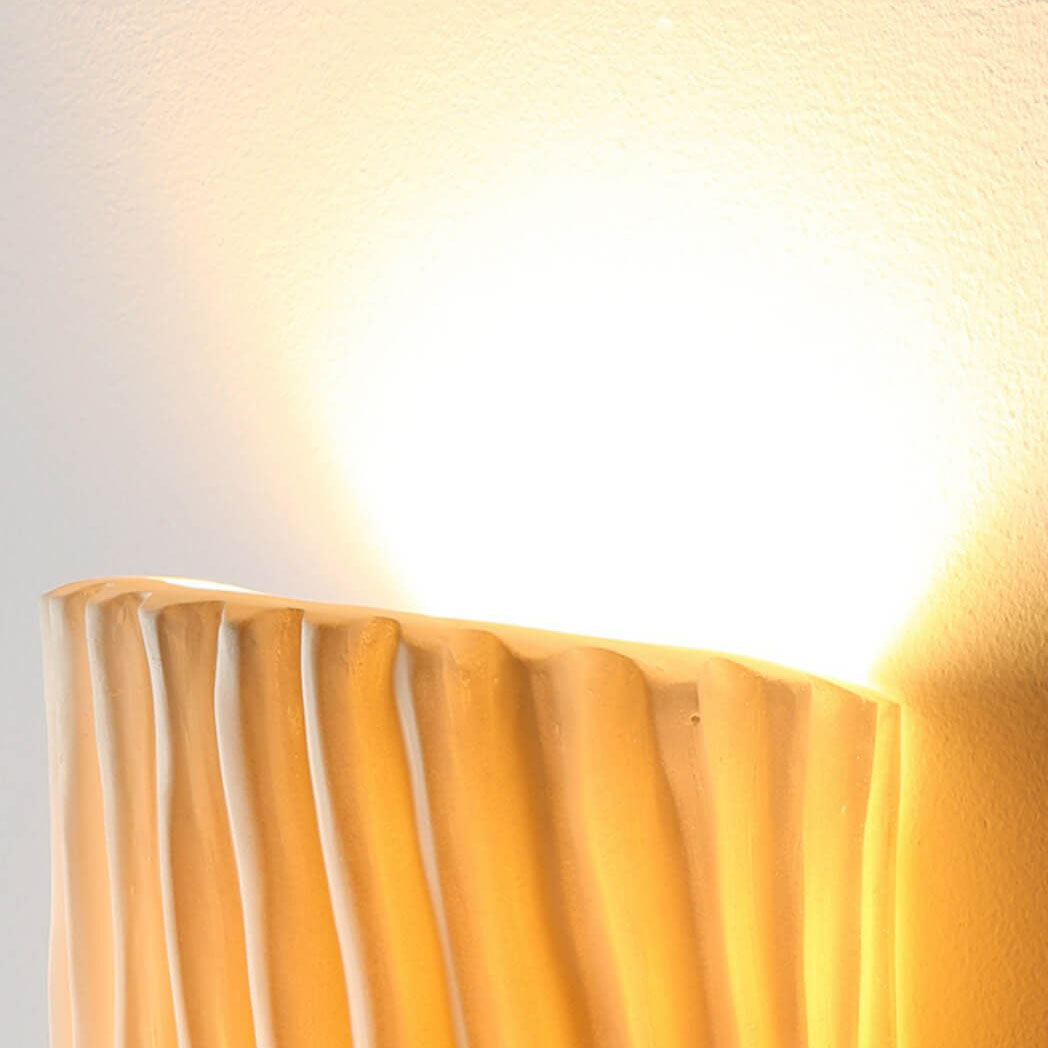 Lámpara de pared de resina con diseño acanalado para dormitorio, toque moderno y funcional.