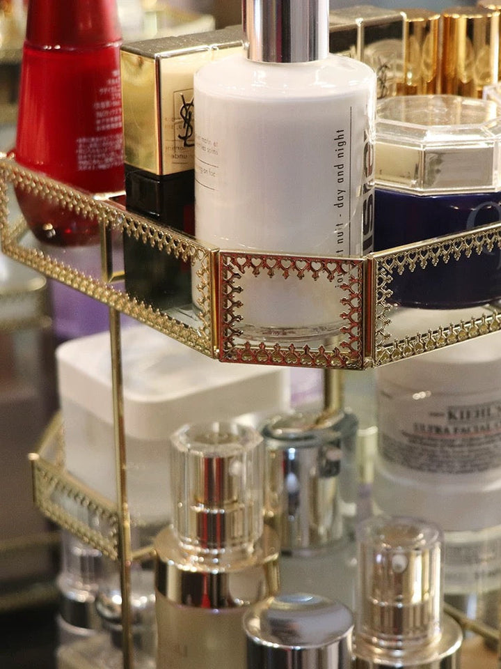 Exhibe y organiza tu maquillaje con este organizador giratorio de vidrio dorado, perfecto para un tocador elegante.