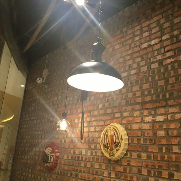 Iluminación decorativa rústica: aplique de pared industrial de hierro con polea, estilo vintage.