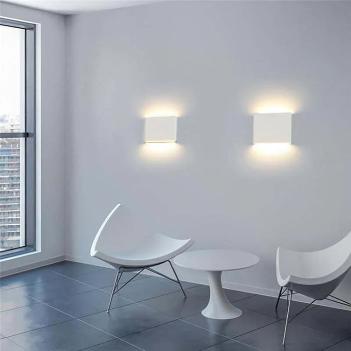 Aplique de pared LED bidireccional instalado en fachada, diseño minimalista moderno e iluminación exterior.