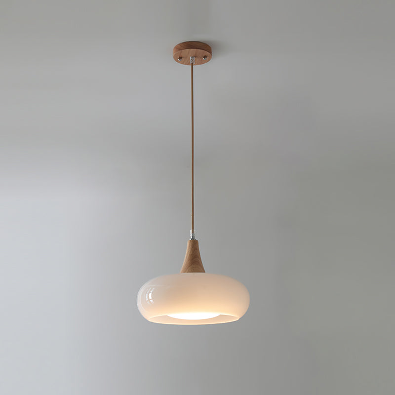 Luz colgante nórdica, vidrio transparente y base de madera, ideal para comedor.