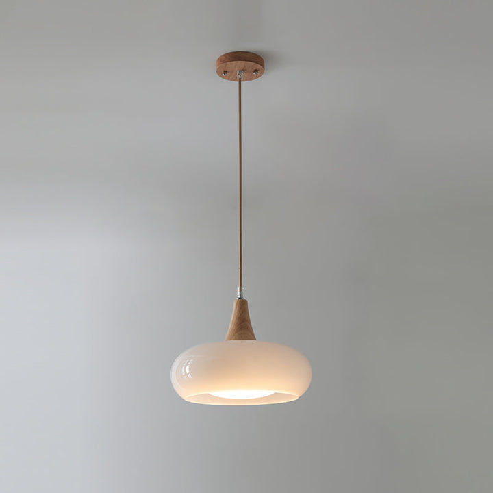 Luz colgante nórdica, vidrio transparente y base de madera, ideal para comedor.