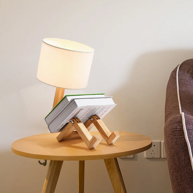 Lámpara de mesa creativa tipo maniquí, madera articulada y pantalla. Diseño moderno para oficina y hogar.