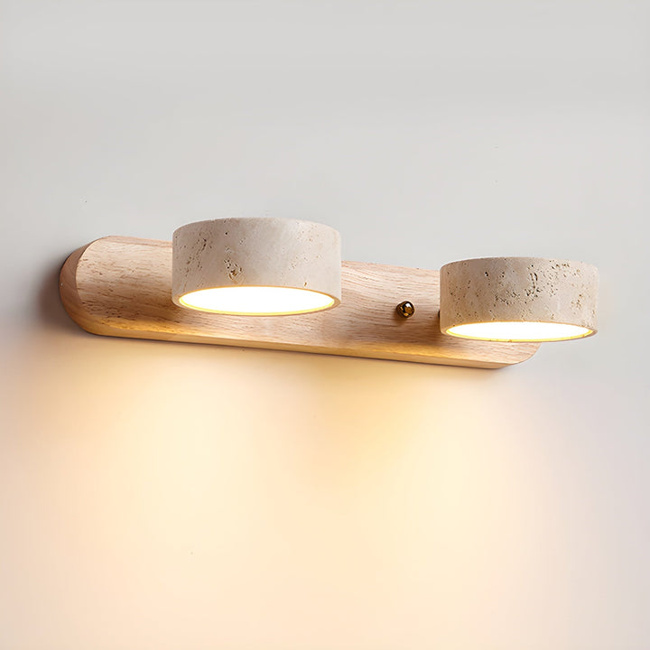 Aplique de pared doble de travertino y nogal instalado, crea un ambiente de luz cálida.