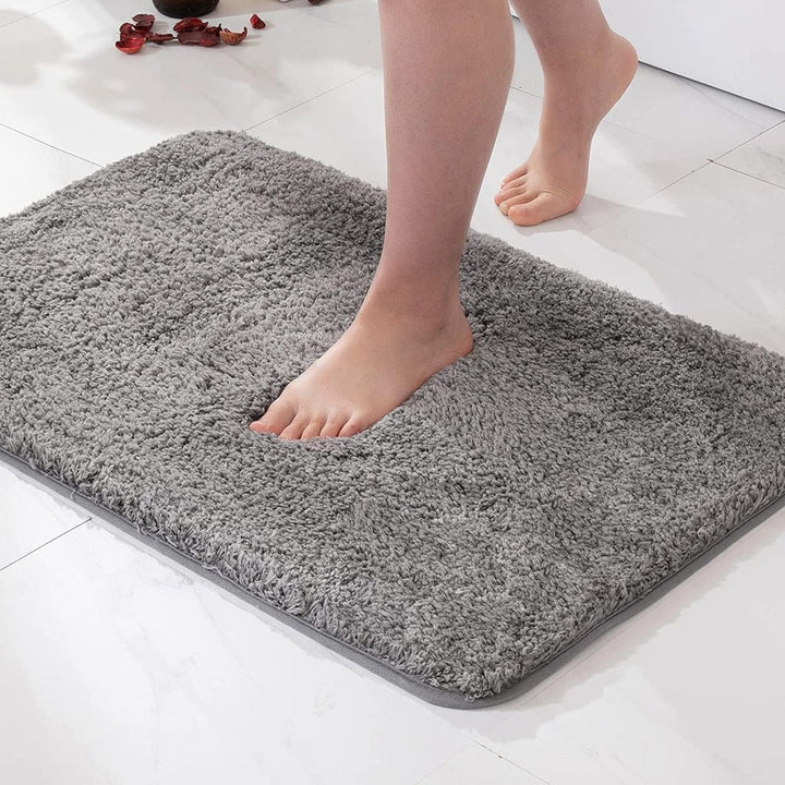 Decorativa alfombra de baño de microfibra suave y piel sintética, absorbente para un hogar acogedor.