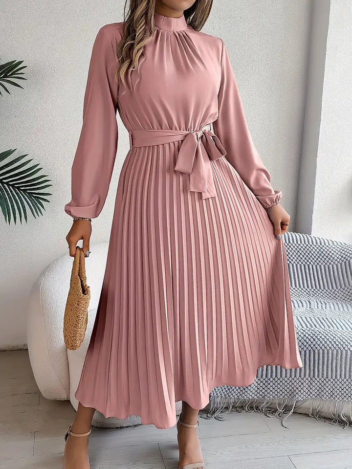 Vestido midi plisado con cinturón que estiliza la figura, mangas largas, ideal para mujer invitada.