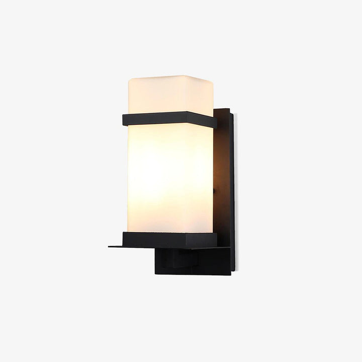 Detalle de aplique de pared exterior. Lámpara de metal y vidrio IP65, elegante y duradera para jardín.