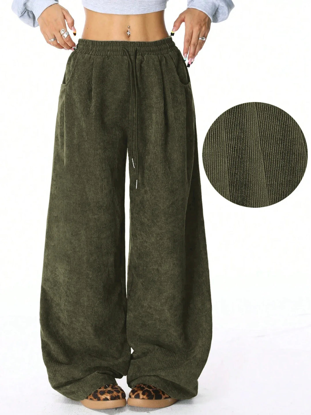 Vista lateral de pantalones de pana pata ancha para mujer, con cordón ajustable, estilo relajado.