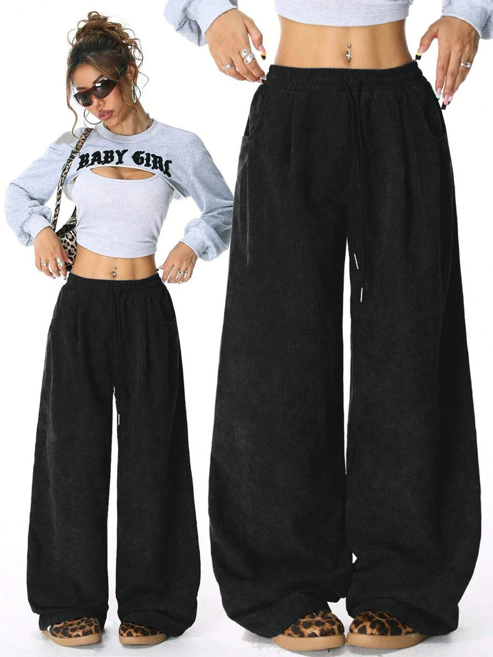 Mujer con pantalones de pana anchos, color marrón, cordón en cintura, look casual moderno.