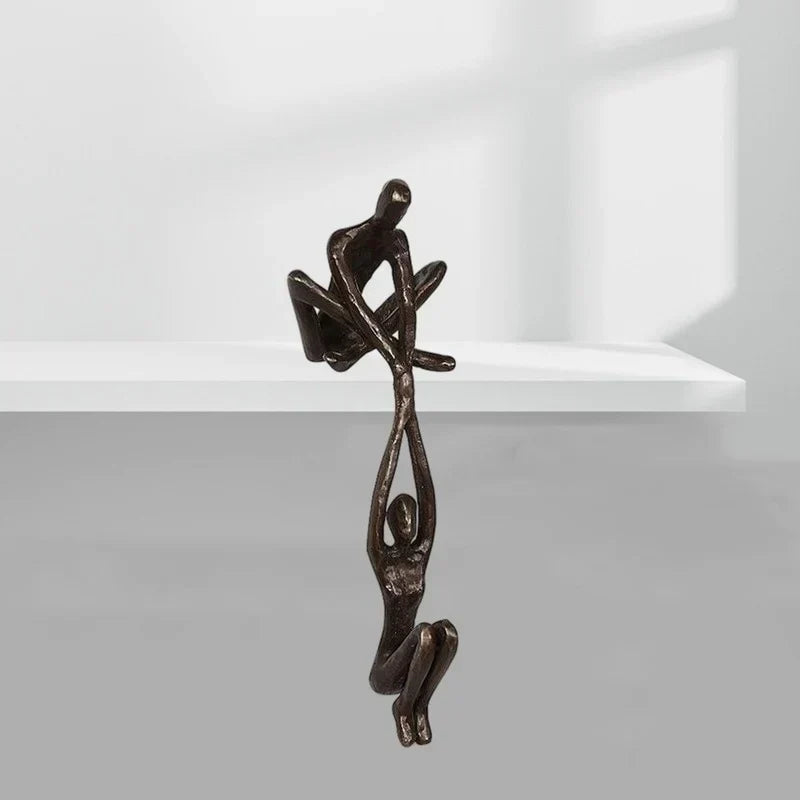 Vista frontal de escultura abstracta figuras humanas, decoración de estante estilo moderno minimalista, negro y bronce.