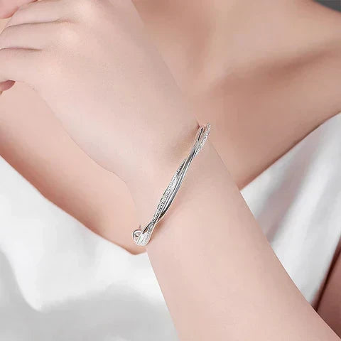 Diseño minimalista de la pulsera Elara, plata trenzada brillante para mujer, un regalo atemporal.